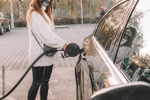 Pumping gas fuel car at oil station. Woman hand refuel petrol nozzle tank. Refueling transportation and Automotive industry.
