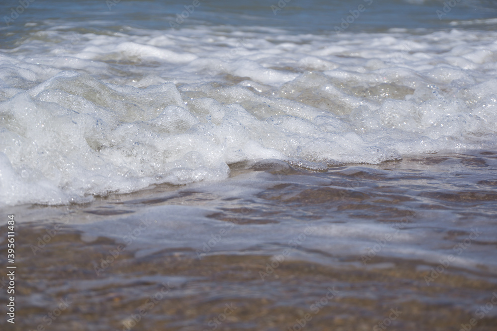 a foam wave of the north sea breaking on the beach
