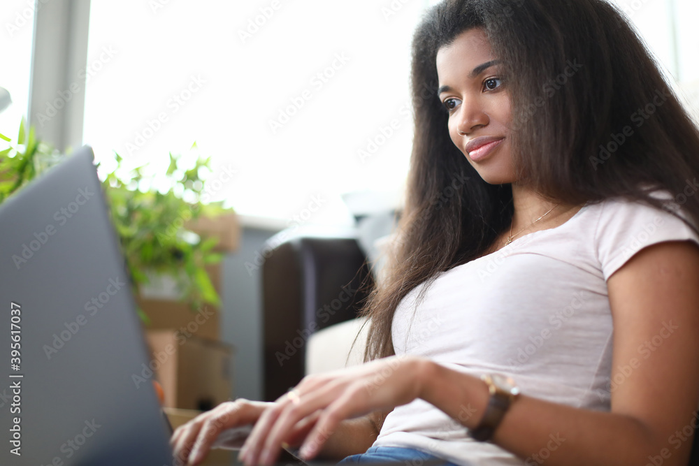 Black woman work remotely on laptop from home. Modern and professional worker via Internet. Black woman work remotely on laptop from home. Modern and professional worker via Internet.
