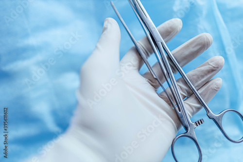 surgical instruments clamps and tweezers in the surgeon s hand