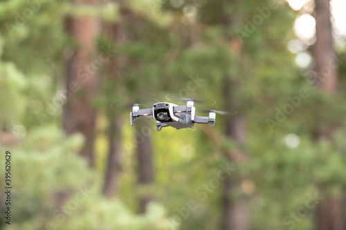 Drone with professional cinema camera flying  in the forests