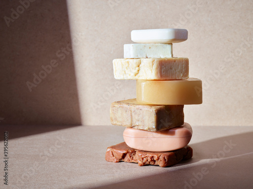 empilement de savons artisanaux pour le corps ou les mains, soins d'hygiène écologiques sur un fond neutre baigné de soleil