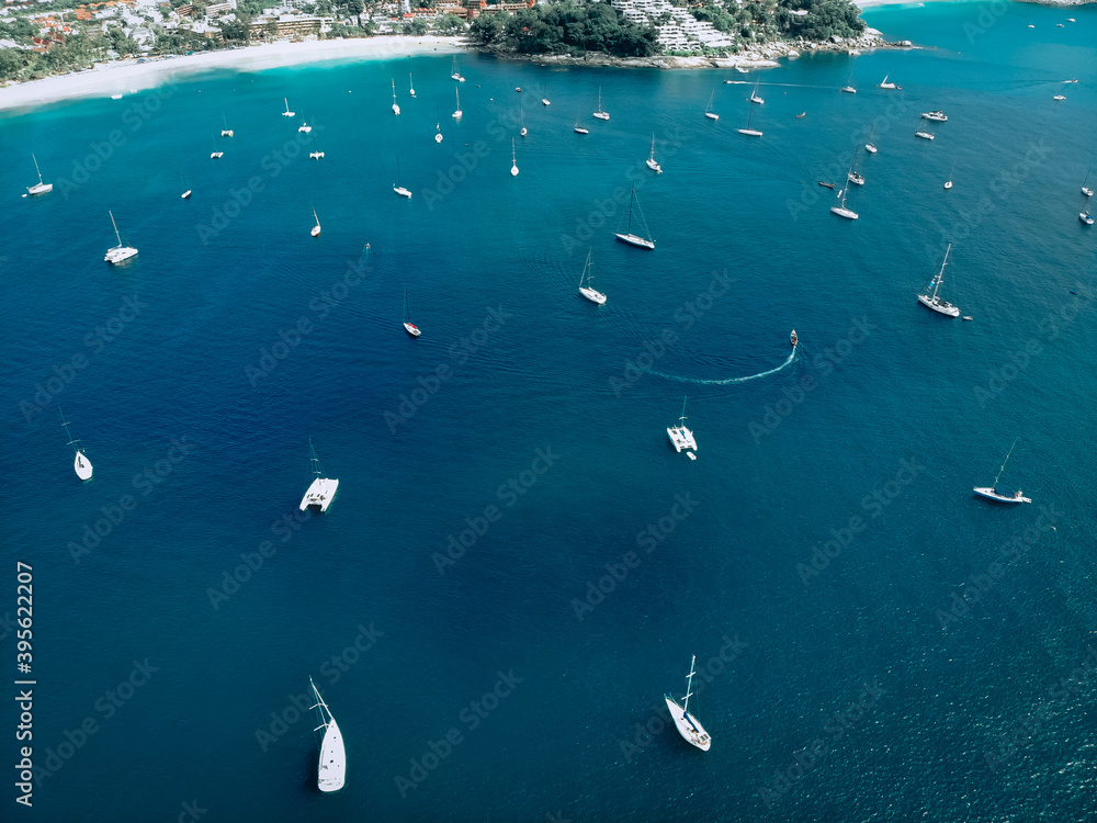 aerial view of many anchoring yacht in open water. Ocean and sea travel and transportation