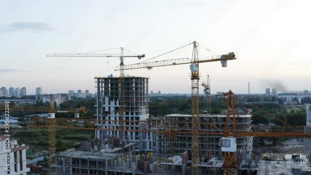 Fly over the construction site, work as construction personnel, builders work, construction houses. Aerial Flight Over a New Constructions Development Site with High Tower Cranes Building Real Estate. Fly over the construction site, work as construction personnel, builders work, construction houses. Aerial Flight Over a New Constructions Development Site with High Tower Cranes Building Real Estate.