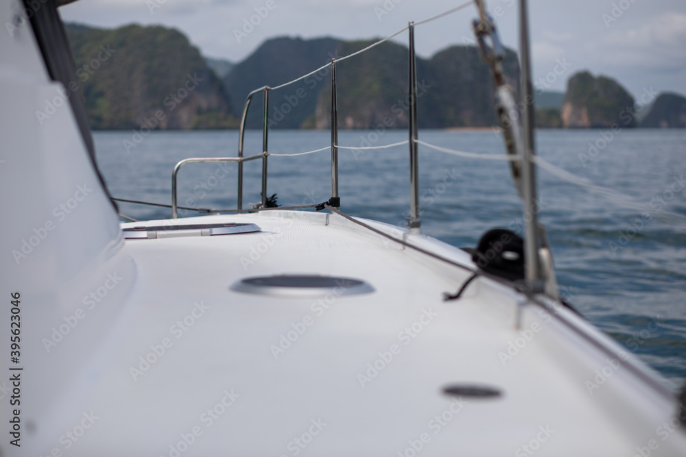 Obraz premium View from board of cutter with blue water and sea foam with a boat seen / yachting sport on a summer sunny day with blue sky/ Concept of speed /boat interior