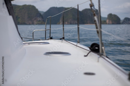 View from board of cutter with blue water and sea foam with a boat seen / yachting sport on a summer sunny day with blue sky/ Concept of speed /boat interior © Semachkovsky 