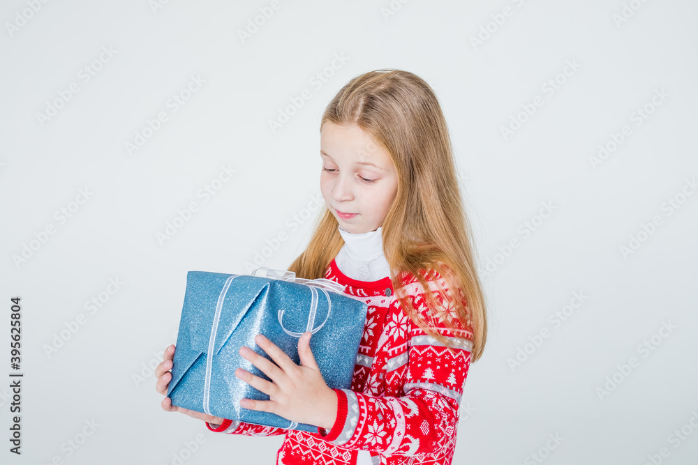 nice girl with Christmas present.Cute kid,child wears red knitted Nordic sweater holding gift, box celebrating. happy 2021 New Year. Merry Christmas presents shopping sale.holidays and people concept nice girl with Christmas present.Cute kid,child wears red knitted Nordic sweater holding gift, box celebrating. happy 2021 New Year. Merry Christmas presents shopping sale.holidays and people concept