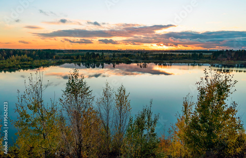 Autumn landscape with beautiful clouds over the lake at sunset.