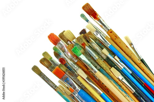 Various dirty paint brushes. Paints and brushes isolated on white background.