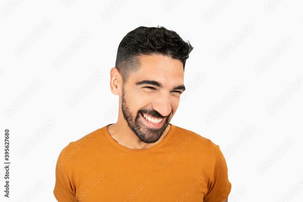 Fototapeta premium Young man smiling against white background.