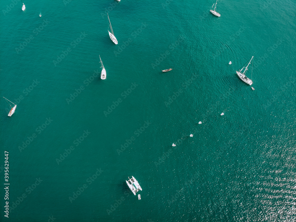 Aerial view of many anchoring yacht in open water. Ocean and sea travel and transportation
