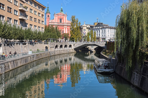 Ljubljana, Slovenia. View on Franciscan Church of the Annunciation and Triple Bridge across the Ljubljanica River. Latin motto on the Baroque facade of the church reads: Hail, full of grace!