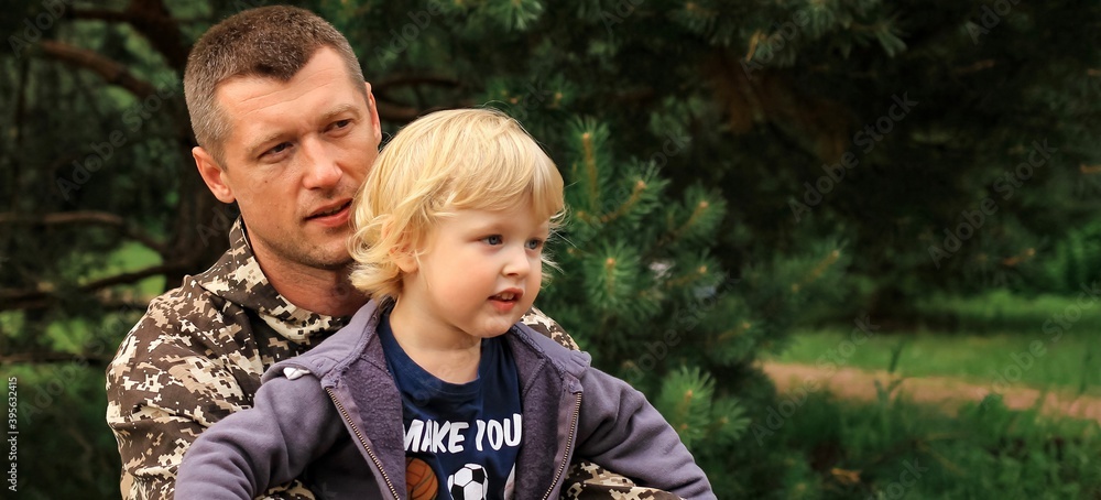Father and son in camouflage ready to play in laser tag shooting game outside. Concept of father's day, military war game, father's return home. Father and son in camouflage ready to play in laser tag shooting game outside. Concept of father's day, military war game, father's return home.