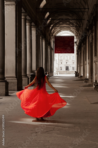 Принти на полотні donna in rosso sotto i portici degli Uffizi a Firenze