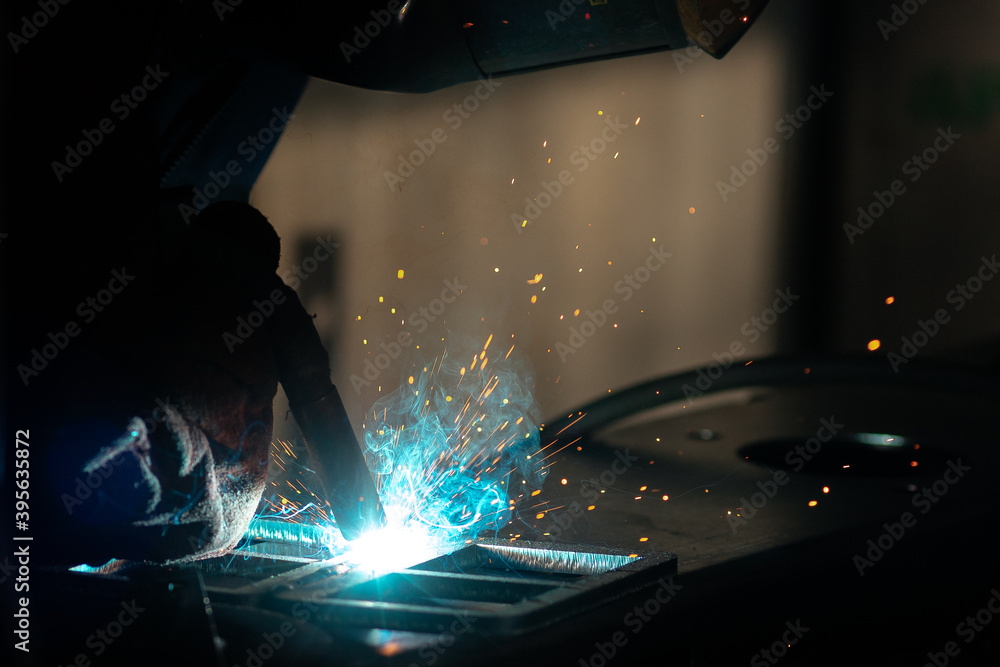 Gas tungsten arc welding of metal with sparks in production and factory mask Gas tungsten arc welding of metal with sparks in production and factory mask