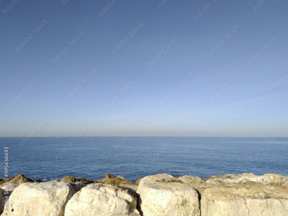 Yellow breakwater stones under the sun.
Stone pier made of yellow carved stones. Sunny day at the mediterranean sea. Light ripples on the water. Clear light blue sky over the sea. ...