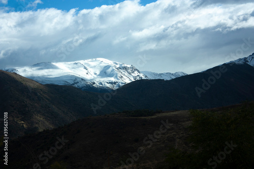 in Andes Merry Christmas and Chilean mountains between clouds and mounds of earth the white snow under the sun