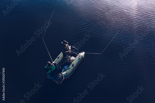 Aerial view of fishermen in a fishing boat in the middle of the lake.