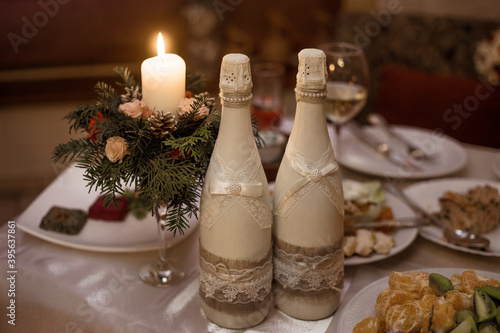 Wedding decor winter. Wedding bottles of champagne and candles.