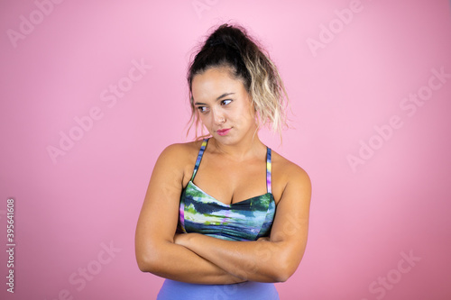 Young beautiful woman wearing sportswear over isolated pink background thinking looking tired and bored with crossed arms