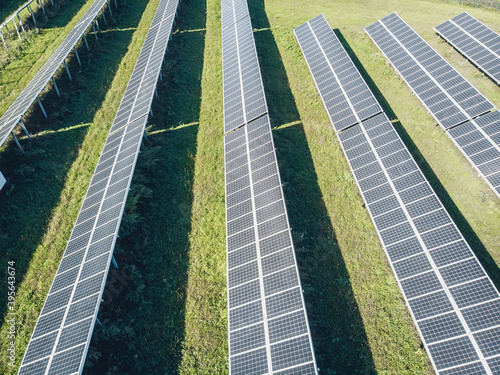 Long Solar panels in a field in a row. View from the drone. Huge Solar panels under the sun. Solar concept