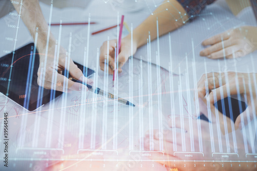 Double exposure of forex graph drawing and man and woman working together holding and using a mobile device. Trade concept.