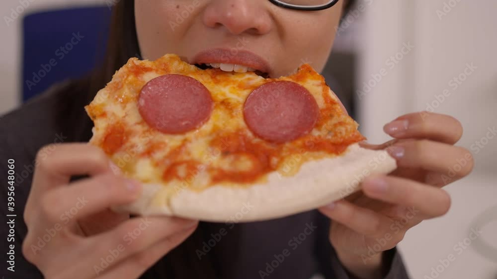 Young woman eats a pizza from delivery service while at work - videoclip Young woman eats a pizza from delivery service while at work - videoclip
