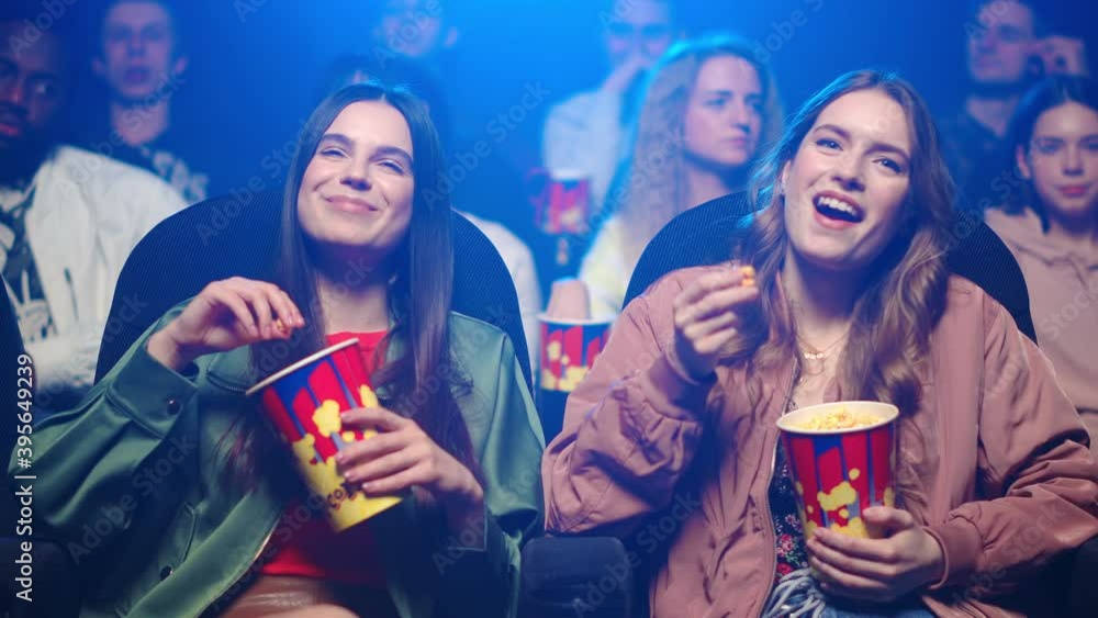 Joyful women having fun in cinema. Cheerful girls laughing in movie theater. Joyful women having fun in cinema. Cheerful girls laughing in movie theater.