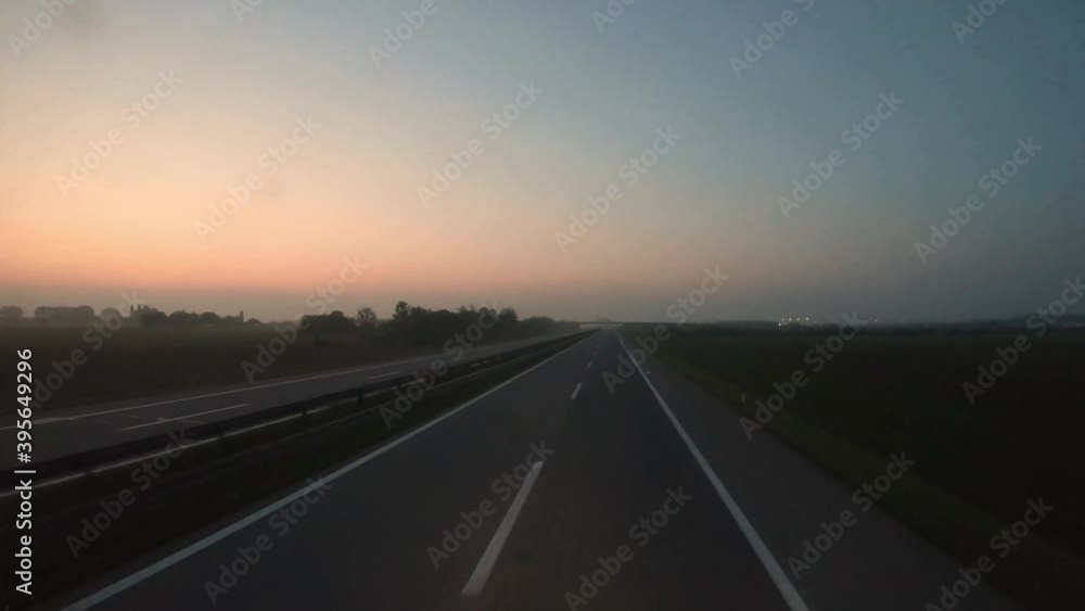 Timelapse of driving on a highway during the pink sunrise in the early foggy morning. Wide angle. Timelapse of driving on a highway during the pink sunrise in the early foggy morning. Wide angle.