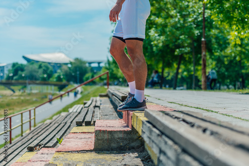 Close up outdoor shoot of male athlete feet with sneakers preparing for running down the stairs