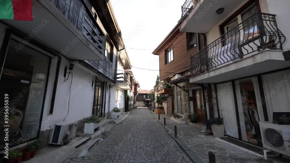 Nessebar, Bugaria - July 25, 2020: Wide angle moving shot from traditional street in Nessebar. Unique design of the houses followed by a stone path between. Nessebar, Bugaria - July 25, 2020: Wide angle moving shot from traditional street in Nessebar. Unique design of the houses followed by a stone path between.