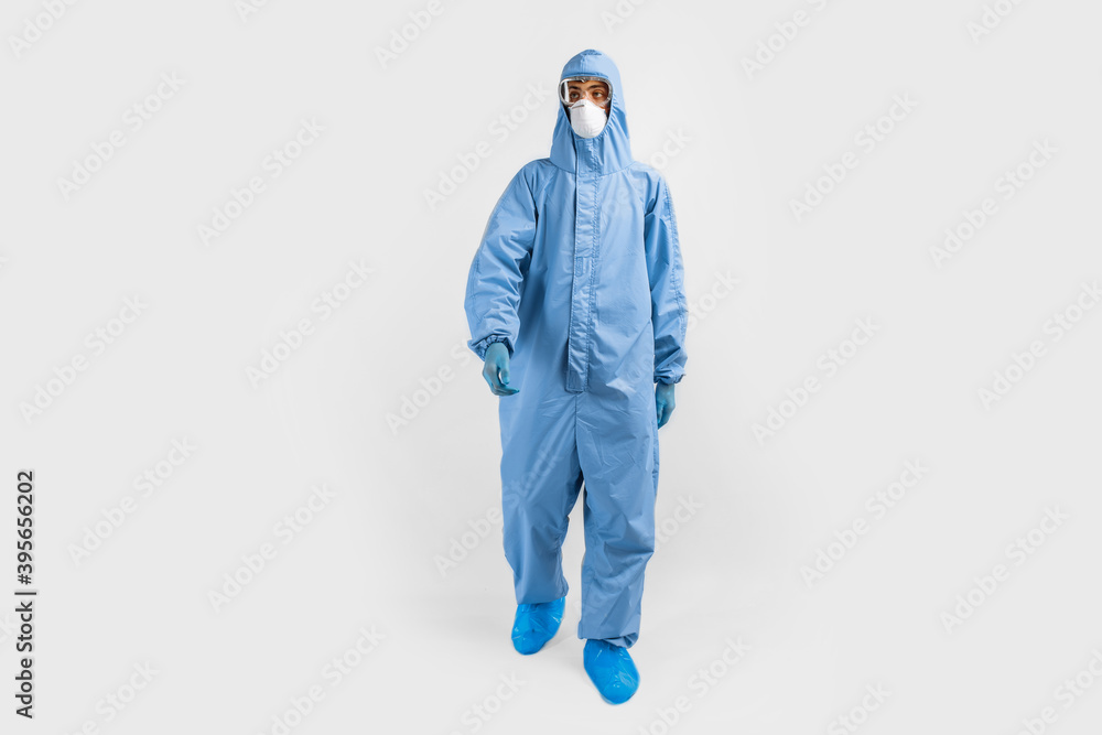 Full-length male doctor in protective clothing, glasses, mask and gloves, on a white background, coronavirus epidemic Full-length male doctor in protective clothing, glasses, mask and gloves, on a white background, coronavirus epidemic