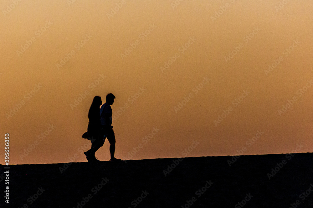 Silhouettes of people at Singing Sands Dune near Dunhuang, Gansu Province, China