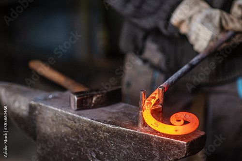 The blacksmith twists the spiral with the help of an anvil, heating the iron blank to red. Work in the forge photo