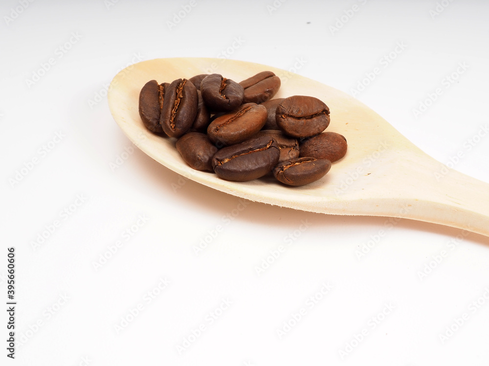 Fototapeta Medium roasted coffee beans on a wooden spoon, shot on a white isolated background