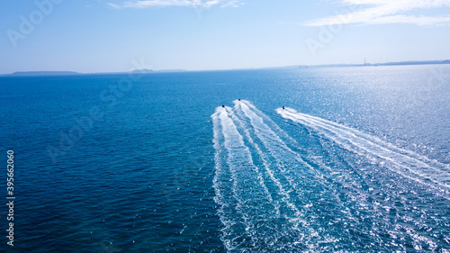 沖に向かうジェットスキーの白波が映える空撮写真
