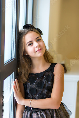 Little girl posing in studio near a large panoramic window