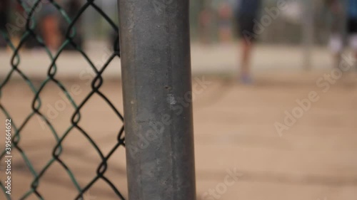 Woman Kicks Kickball in Background of Fence photo
