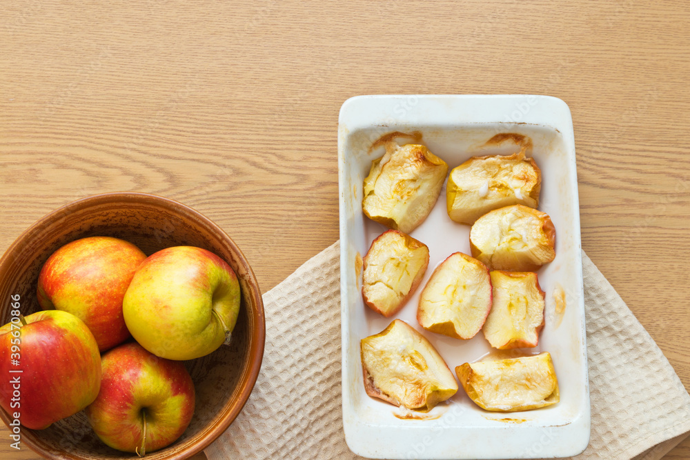 Freshly baked sweet apples in ceramic form on a wooden table. Delicious organic sweets rich in fiber. Digestible food for elderly people, children and people with health problems. Flat lay, copy space Freshly baked sweet apples in ceramic form on a wooden table. Delicious organic sweets rich in fiber. Digestible food for elderly people, children and people with health problems. Flat lay, copy space