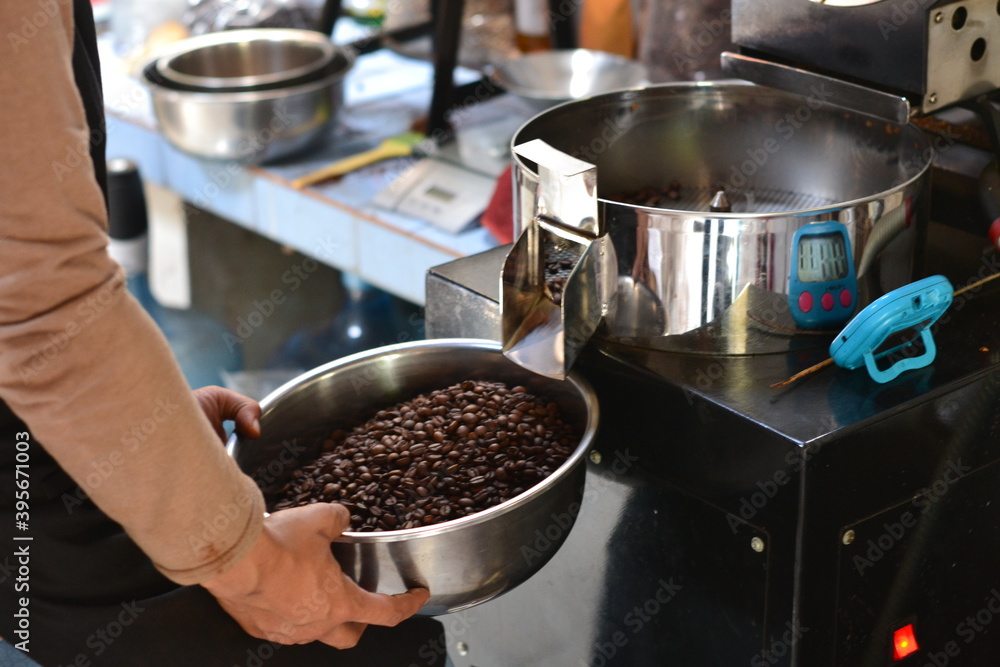 Close up professional coffee roaster holding bowl with beans. Control concept Close up professional coffee roaster holding bowl with beans. Control concept