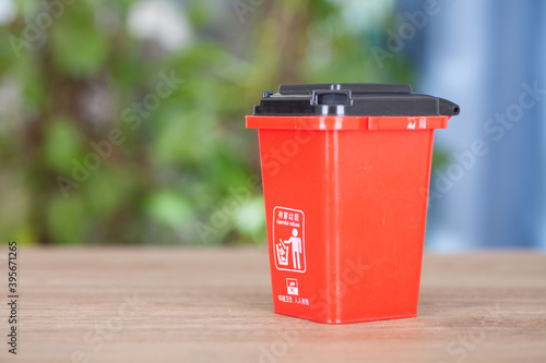 A model of a red classified hazardous waste bin on the table