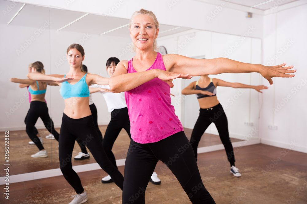 Obraz premium Group of active smiling people dancing together in dance studio. High quality photo