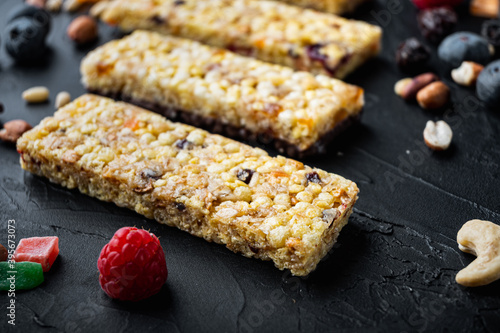 Homemade granola bars with mixed nuts, seeds, berries,on black background