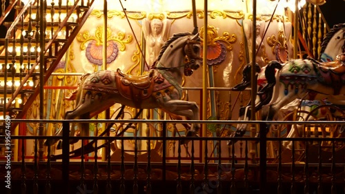 Horses inside moving Carousel, roundabout or merry-go-round surround with colorful lights