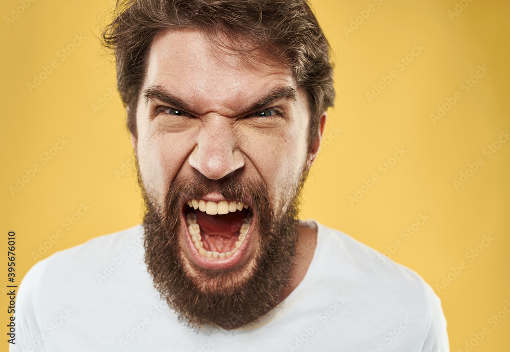 irritable young man with beard on yellow background cropped view irritable young man with beard on yellow background cropped view