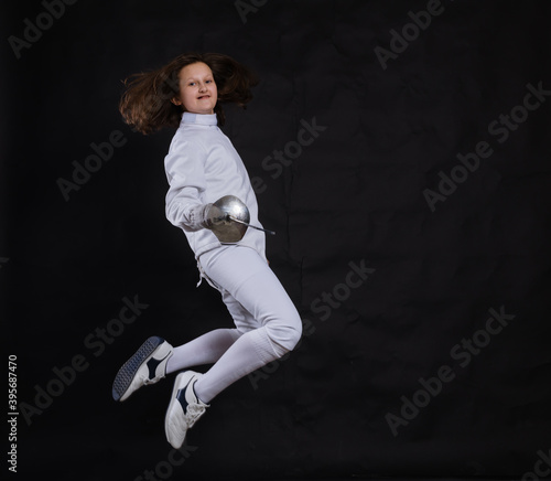 Teenage girl fencer dressed in uniform with epee and helmet