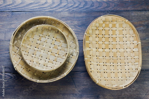 Piring Anyaman Bamboo or bamboo woven set plate on rustic wooden background. Top view. photo