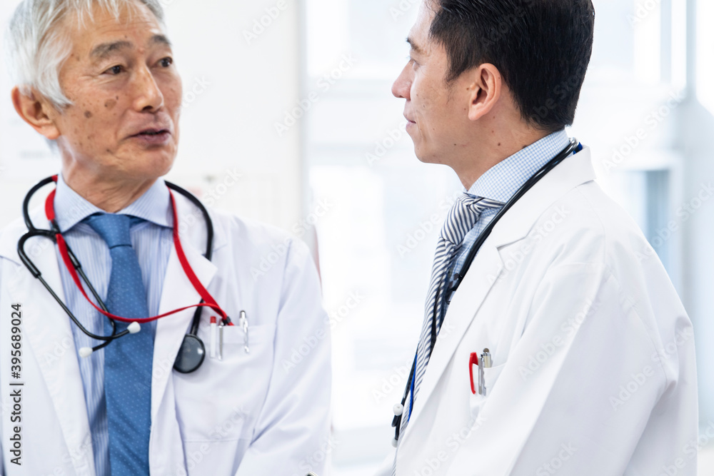 ナースステーションで会話をする医師。横顔