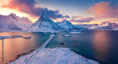 Amazing view from flying drone of Lofoten Islands. Colorful winter sunrise on Norway, Europe. Aerial morning view of Fredvang bridge with Volandstind peak on background. Life over polar circle.