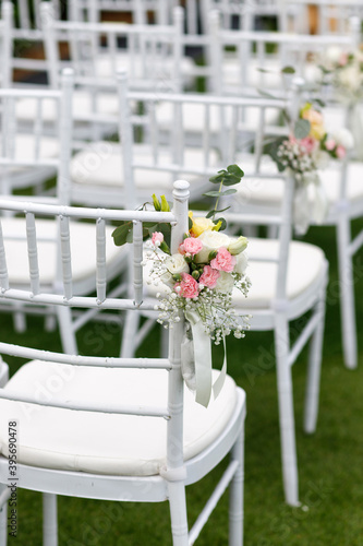 Outdoor wedding venue chairs with flower and ribbon decoration